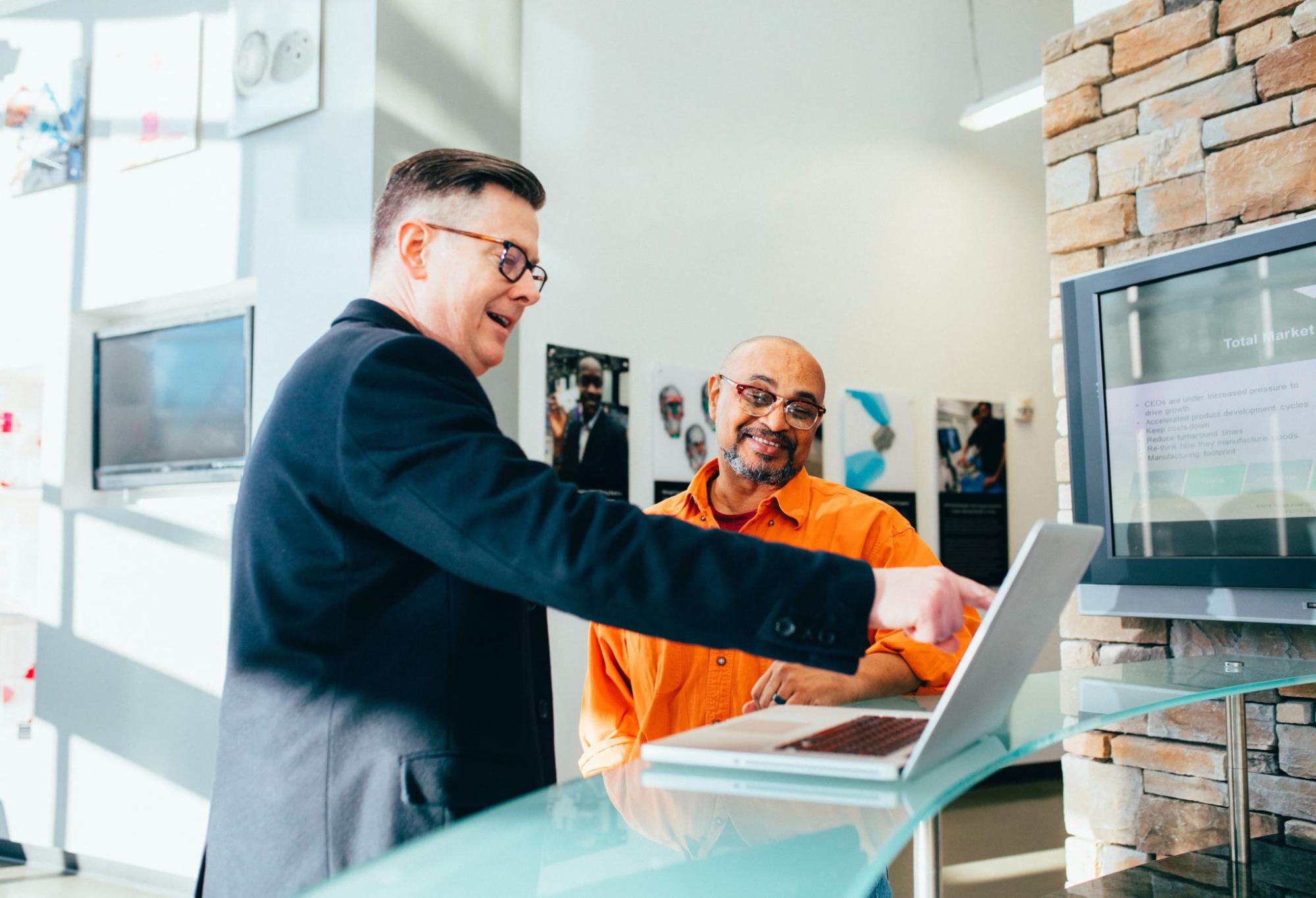 Sales rep with laptop talking to a customer in a lobby