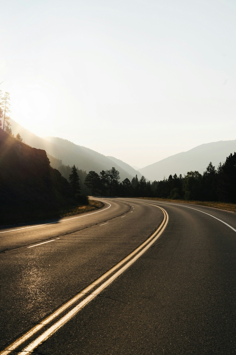 Open road curving through mountains at golden hour
